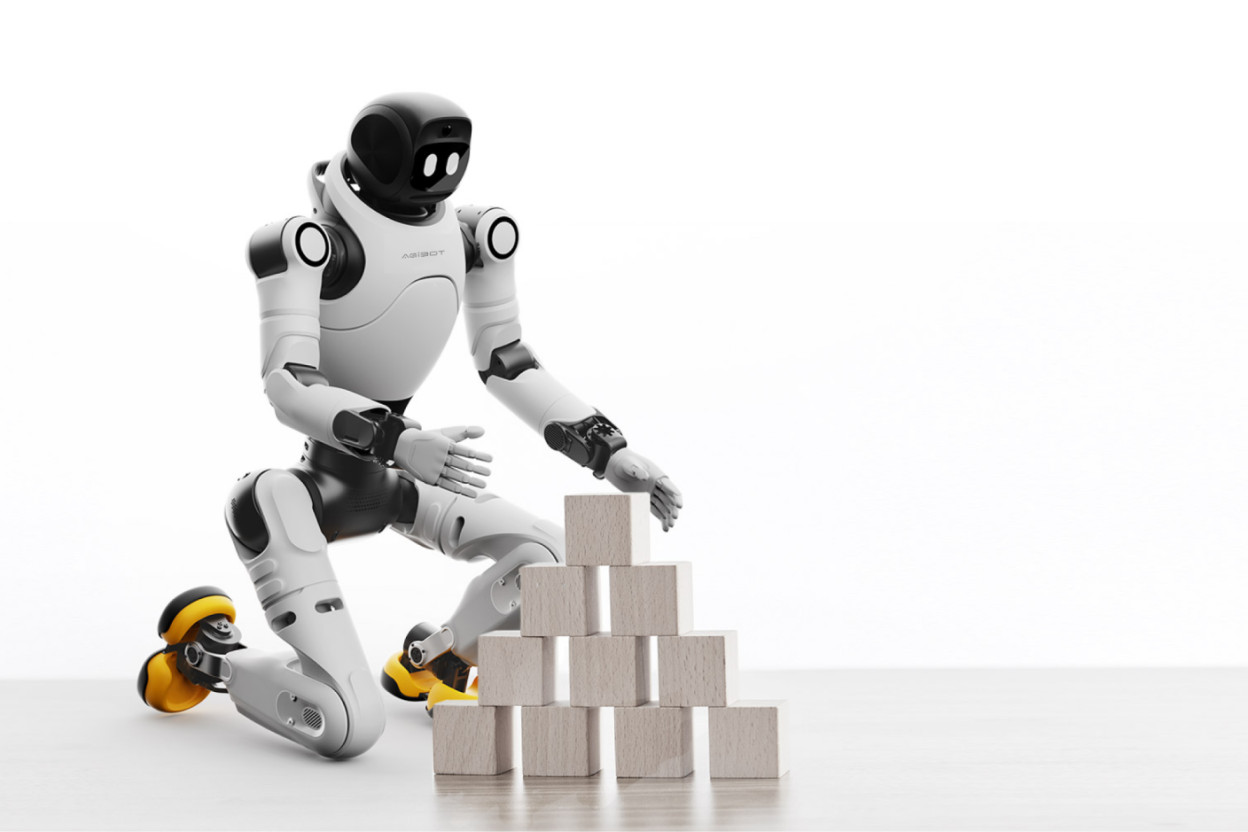 Robot humanoïde AgiBot X2 agenouillé manipulant des blocs en bois sur fond blanc