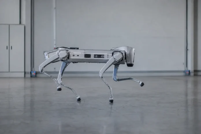 Chery meldet über 2.000 exportierte Mojai-Roboter und will bis 2030 100.000 Robotaxis einsetzen Illustration: vierbeiniger Roboter mit gelenkigen Beinen in einer Industrieumgebung, zum Export von Mojai-Robotern durch Chery