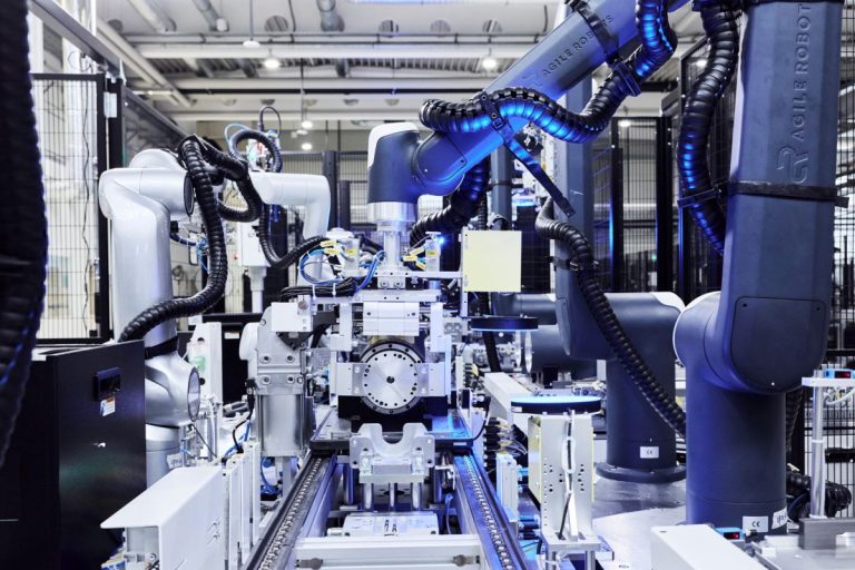 Robot humanoïde en cours d'assemblage sur un poste de travail dans une usine