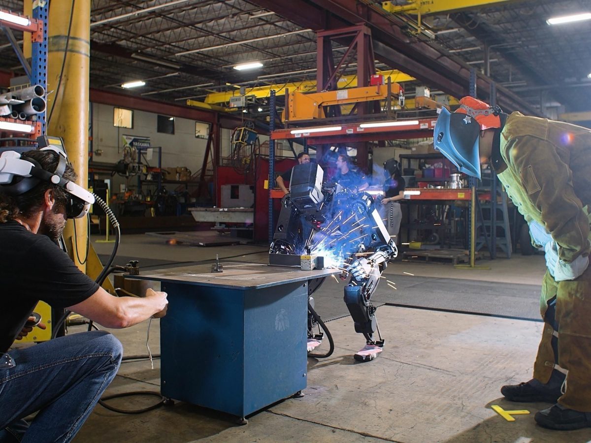 Robot humanoïde manipulant un outil de soudage dans un environnement d'atelier