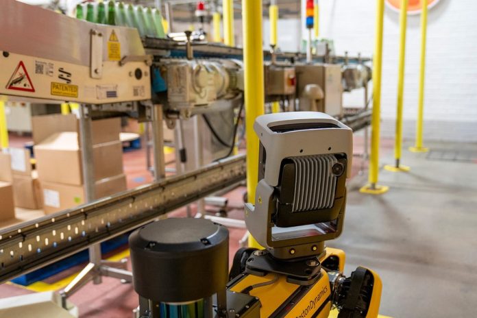 Robot quadrupède jaune Spot de Boston Dynamics sur un sol industriel gris