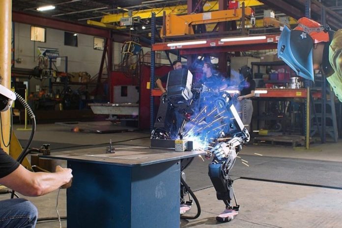 Robot humanoïde bipède blanc avec bras articulés dans un atelier industriel