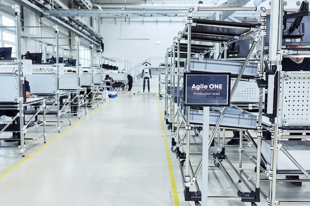 Ligne de production automatisée avec des robots et des postes d'assemblage dans un hall industriel