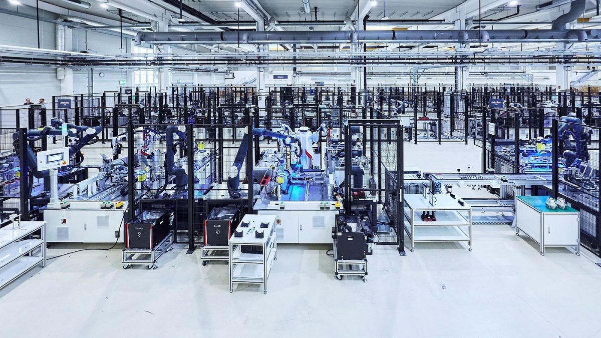 Robot mobile transportant un plateau de pièces dans une halle d'assemblage